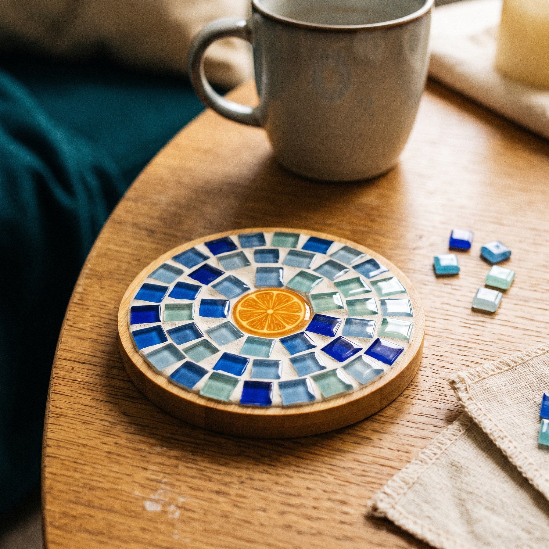 Colourful glass mosaic coaster beside a cup
