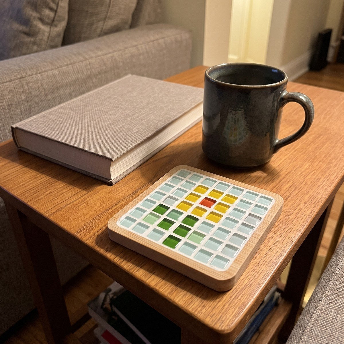 Adult maker holding a finished bamboo mosaic coaster
