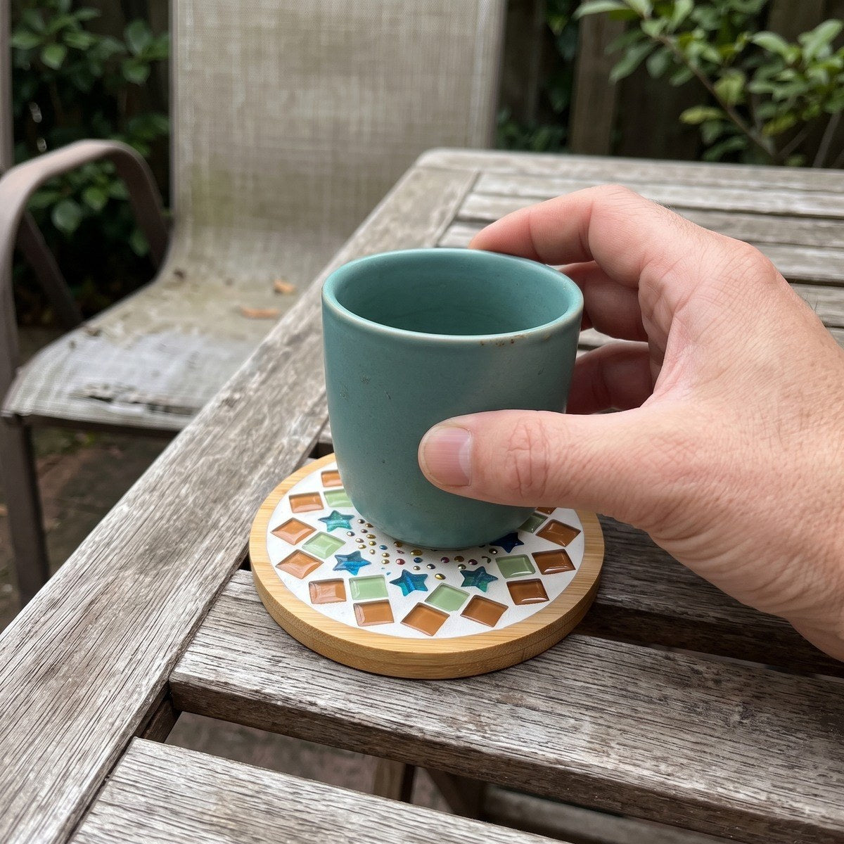 Adult maker with a mosaic coaster on a covered porch